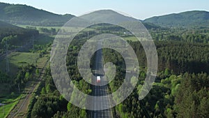 Aerial view of an empty road on which a truck with a semi-trailer is moving.