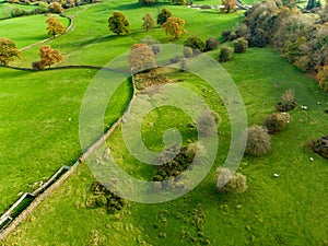 Aerial view of endless lush pastures and farmlands of England. Beautiful English countryside with emerald green fields and meadows