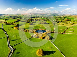 Aerial view of endless lush pastures and farmlands of England. Beautiful English countryside with emerald green fields and meadows