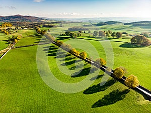 Aerial view of endless lush pastures and farmlands of England. Beautiful English countryside with emerald green fields and meadows