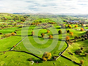 Aerial view of endless lush pastures and farmlands of England. Beautiful English countryside with emerald green fields and meadows