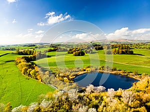 Aerial view of endless lush pastures and farmlands of England. Beautiful English countryside with emerald green fields and meadows