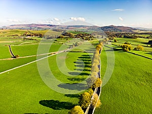 Aerial view of endless lush pastures and farmlands of England. Beautiful English countryside with emerald green fields and meadows