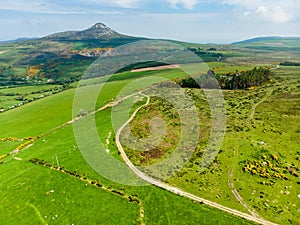 Aerial view of endless lush pastures and farmlands of Ireland. Beautiful Irish countryside with emerald green fields and meadows