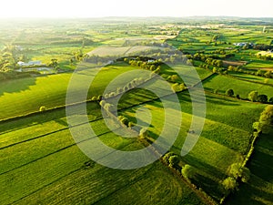 Aerial view of endless lush pastures and farmlands of Ireland. Beautiful Irish countryside with emerald green fields and meadows. photo