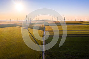 Aerial view of Eolian generators in a beautiful wheat field. Eolian turbine farm. Wind turbine silhouette. Wind field turbines. Wi
