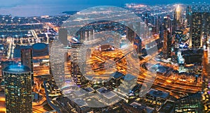 Aerial View Of Evening Night Scenic View Of Skyscraper In Dubai. Street Night Traffic In Dudai Skyline. Waterfront And