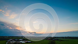 Aerial view of an evening sky over the fields overcast with thunder storm clouds coming in on the sunrise or sunset