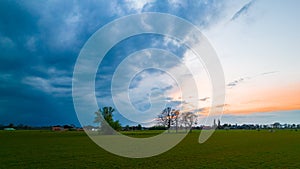 Aerial view of an evening sky over the fields overcast with thunder storm clouds coming in on the sunrise or sunset