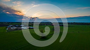 Aerial view of an evening sky over the fields overcast with thunder storm clouds coming in on the sunrise or sunset