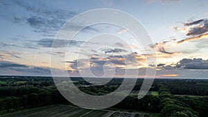 Aerial view of an evening sky over the fields overcast with thunder storm clouds coming in on the sunrise or sunset