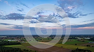 Aerial view of an evening sky over the fields overcast with thunder storm clouds coming in on the sunrise or sunset