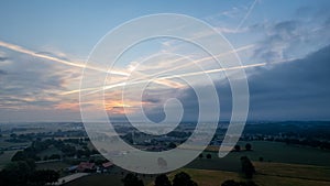 Aerial view of an evening sky over the fields overcast with thunder storm clouds coming in on the sunrise or sunset