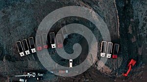 Aerial view of excavator and dump trucks in construction site by the sea side. Construction industry