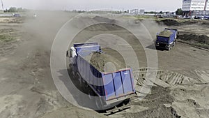 Aerial view of excavator scoop clay soil to a dump truck. Scene. Activity at the construction site, heavy industry