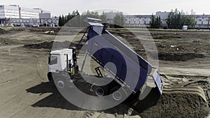 Aerial view of excavator scoop clay soil to a dump truck. Scene. Activity at the construction site, heavy industry