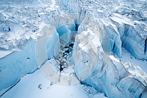 aerial view of expansive glacier with deep crevasses