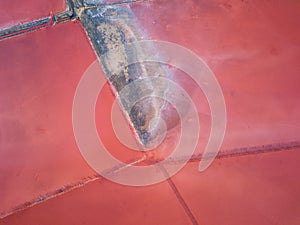 Aerial view of extremely salty lake with wooden logs for salt extraction in the pink water, natural abstract background