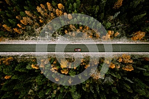 Aerial view of fall road with autumn woods and first snow in Finland