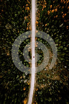 Aerial view of fall road with autumn woods and first snow in Finland