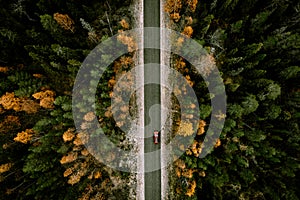 Aerial view of fall road with autumn woods and first snow in Finland