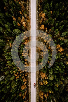 Aerial view of fall road with autumn woods and first snow in Finland