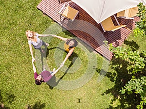 Aerial view of the family with a drone. The family playing roundelay in their backyard.