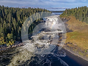 Aerial view famous waterfall Tannforsen northern Sweden, with a rainbow in the mist and rapid flowing cascades of water