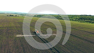 Aerial view Farm machinery spraying insecticide to the green field, agricultural natural seasonal spring works. Farming