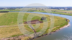 Aerial view of the farm surrounded by a beautiful river and lush green grass near Newcastle