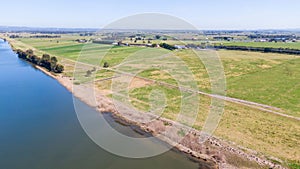 Aerial view of the farm surrounded by a beautiful river and lush green grass near Newcastle