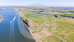 Aerial view of the farm surrounded by a beautiful river and lush green grass near Newcastle