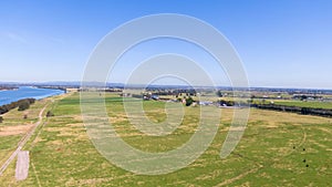 Aerial view of the farm surrounded by a beautiful river and lush green grass near Newcastle