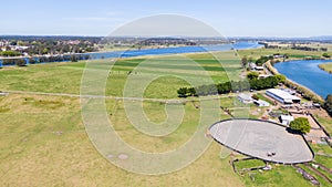 Aerial view of the farm surrounded by a beautiful river and lush green grass near Newcastle