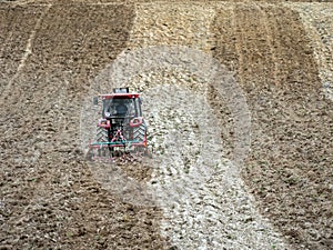 Farm tractor harrowing arable field photo