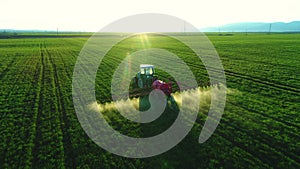 Aerial view of farming tractor plowing and spraying on field