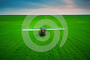 Aerial view of farming tractor plowing and spraying on field