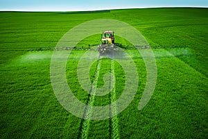 Aerial view of farming tractor plowing and spraying on field