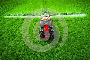 Aerial view of farming tractor plowing and spraying on field