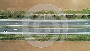 Aerial view of farmland, rapeseed and wheat fields, and highway road in the countryside
