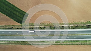 Aerial view of farmland, rapeseed and wheat fields, and highway road in the countryside