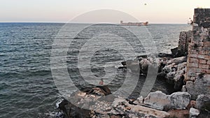 Aerial view female person on rock takes selfie with sea view and famous touristic landmark Kiz kalesi