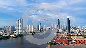 Aerial view of the ferris wheel, Asiatique The Riverfront, near Chao Phraya River with skyscraper buildings in Bangkok Downtown at