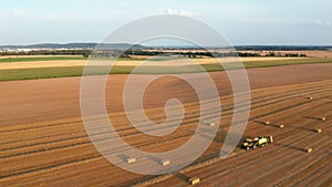 Aerial view of the field with hay bales or straw bales after harvest.