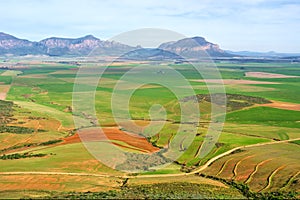 Aerial view of fields in front of misty mountains