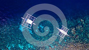 Aerial view of Filipino boats floating on top of clear blue waters, Moalboal is a deep clean blue ocean and has many local