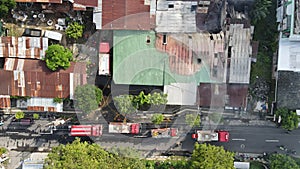 Aerial view of firefighters extinguishing the ruins of a burning furniture factory building with a collapsed roof and billowing