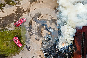 Aerial view of firemen fighting with fire near old factory biulding in industrial area