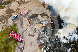 Aerial view of firemen fighting with fire near old factory biulding in industrial area