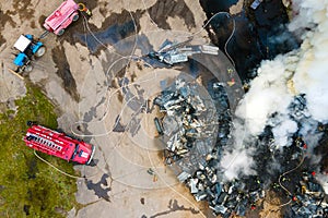 Aerial view of firemen fighting with fire near old factory biulding in industrial area